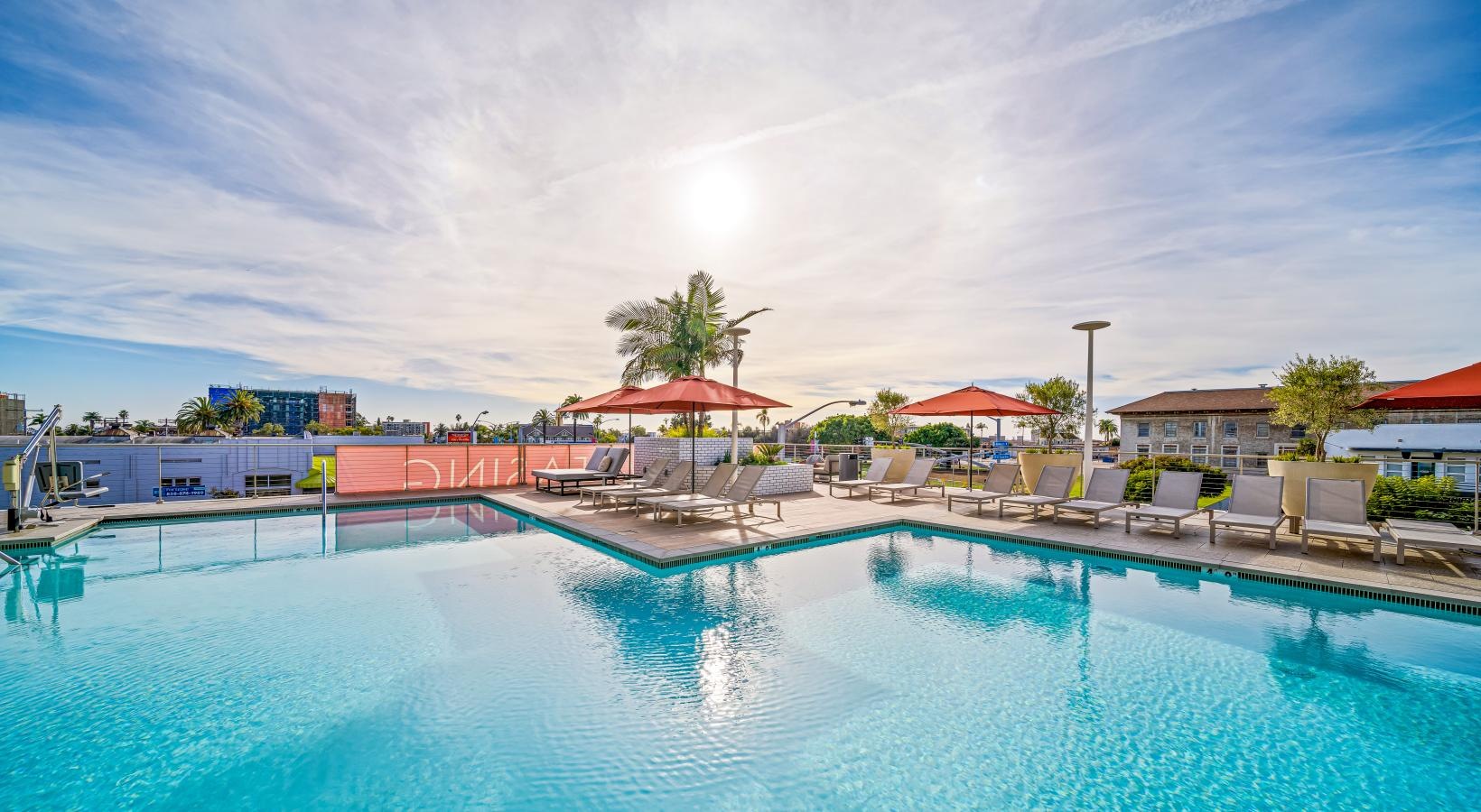 Resort-style swimming pool a pool with chairs and umbrellas