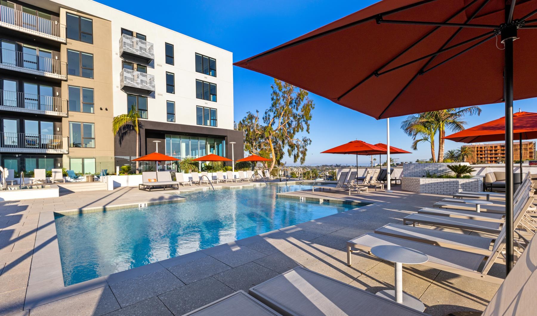 Find your perfect fit at Winslow a pool with umbrellas and chairs next to it