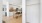 a kitchen with white cabinets and an empty closet